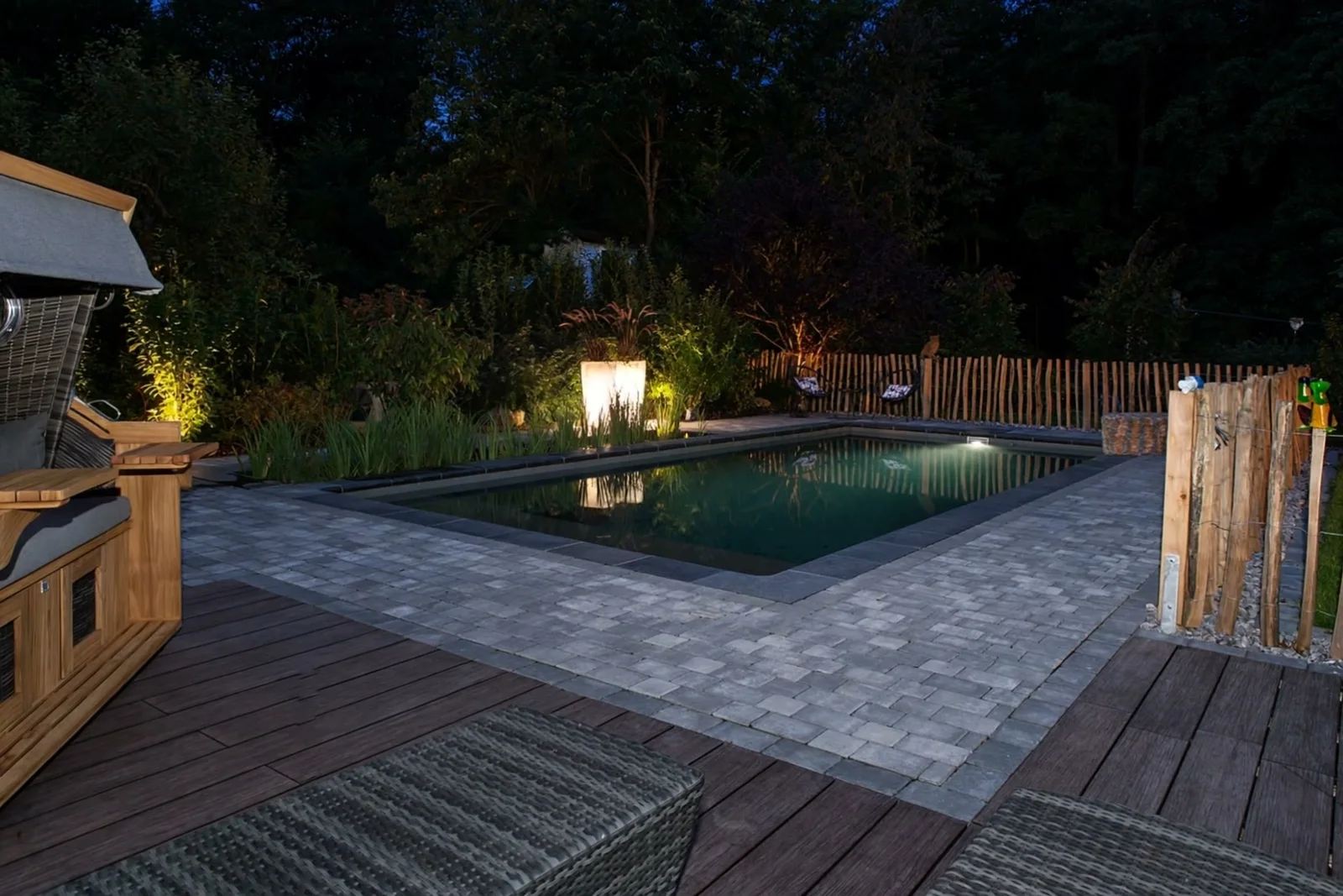 Beleuchteter Naturpool-Garten am Abend
