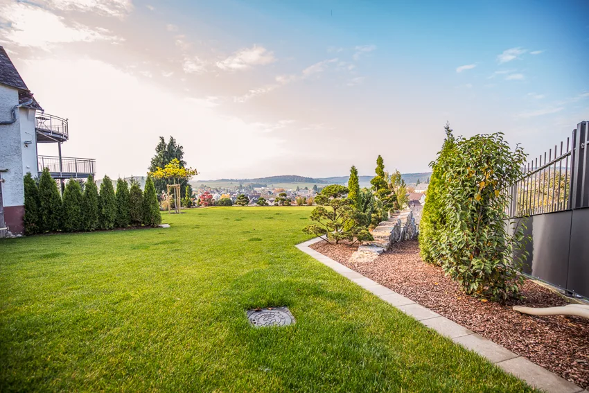 Gepflegte Gartenanlage nach Baumschnitt, Mulchen und Düngen