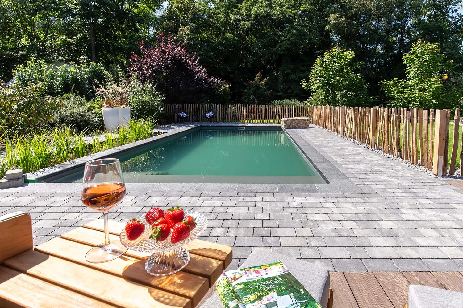 Schwimmteich mit Ruhezonen und Bepflanzung in einem Garten in Burbach